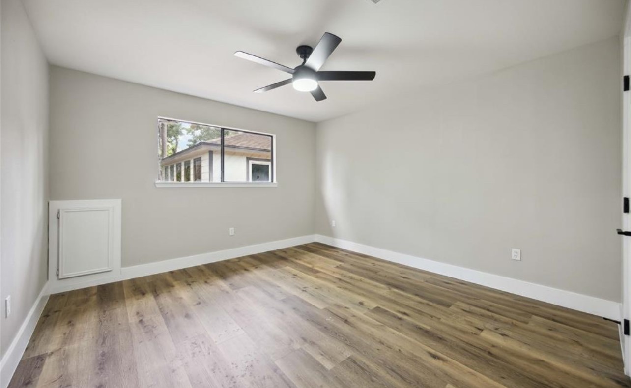 8143 Northbridge Drive Spring, TX 77379 - Photo 22 of 30 an empty room with wooden floor ceiling fan and windows