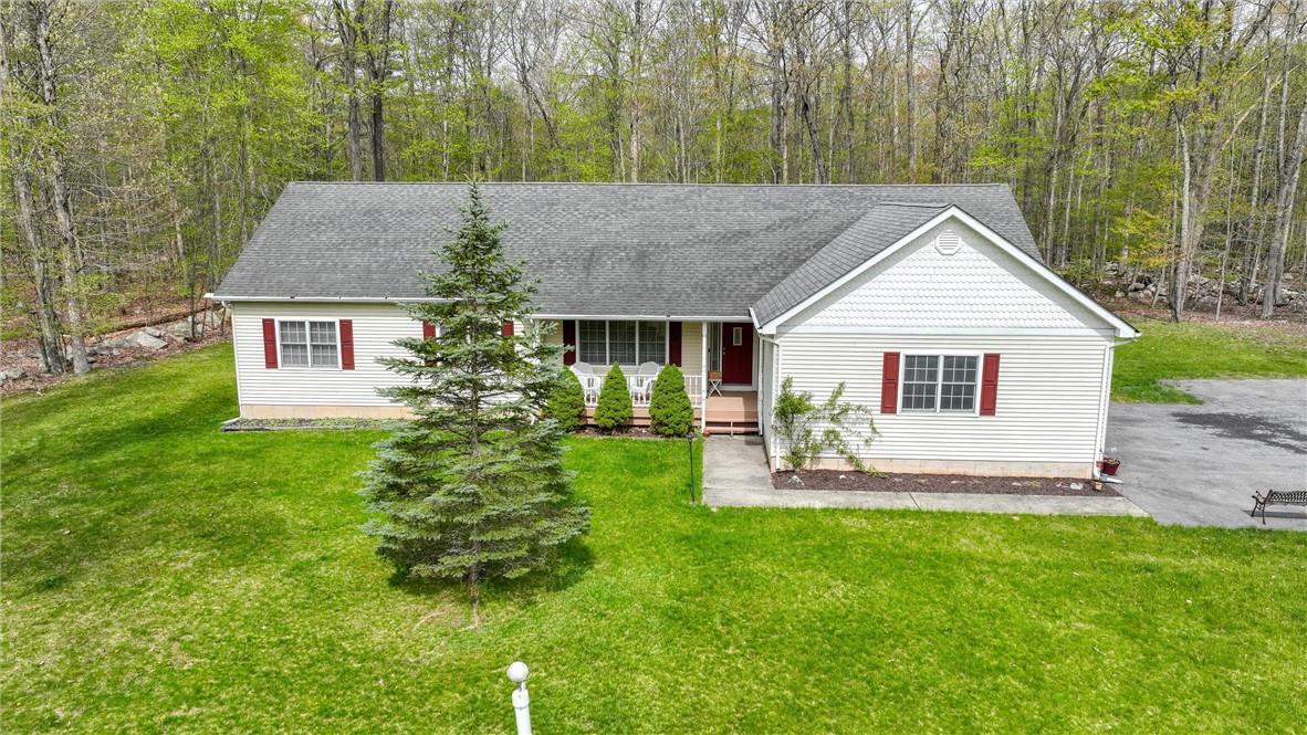 a view of a house with a yard and sitting area