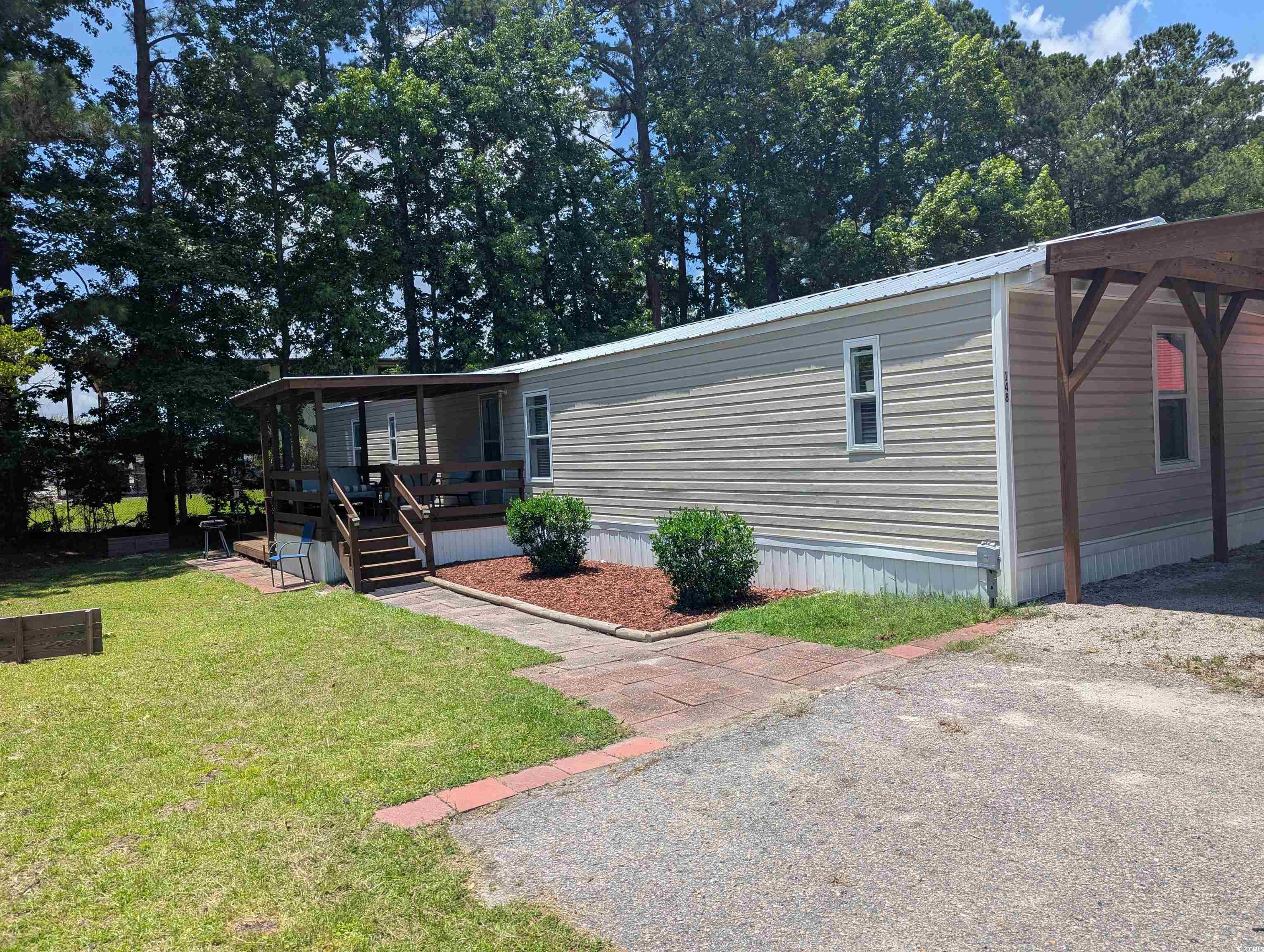 View of front facade featuring a front yard and a deck