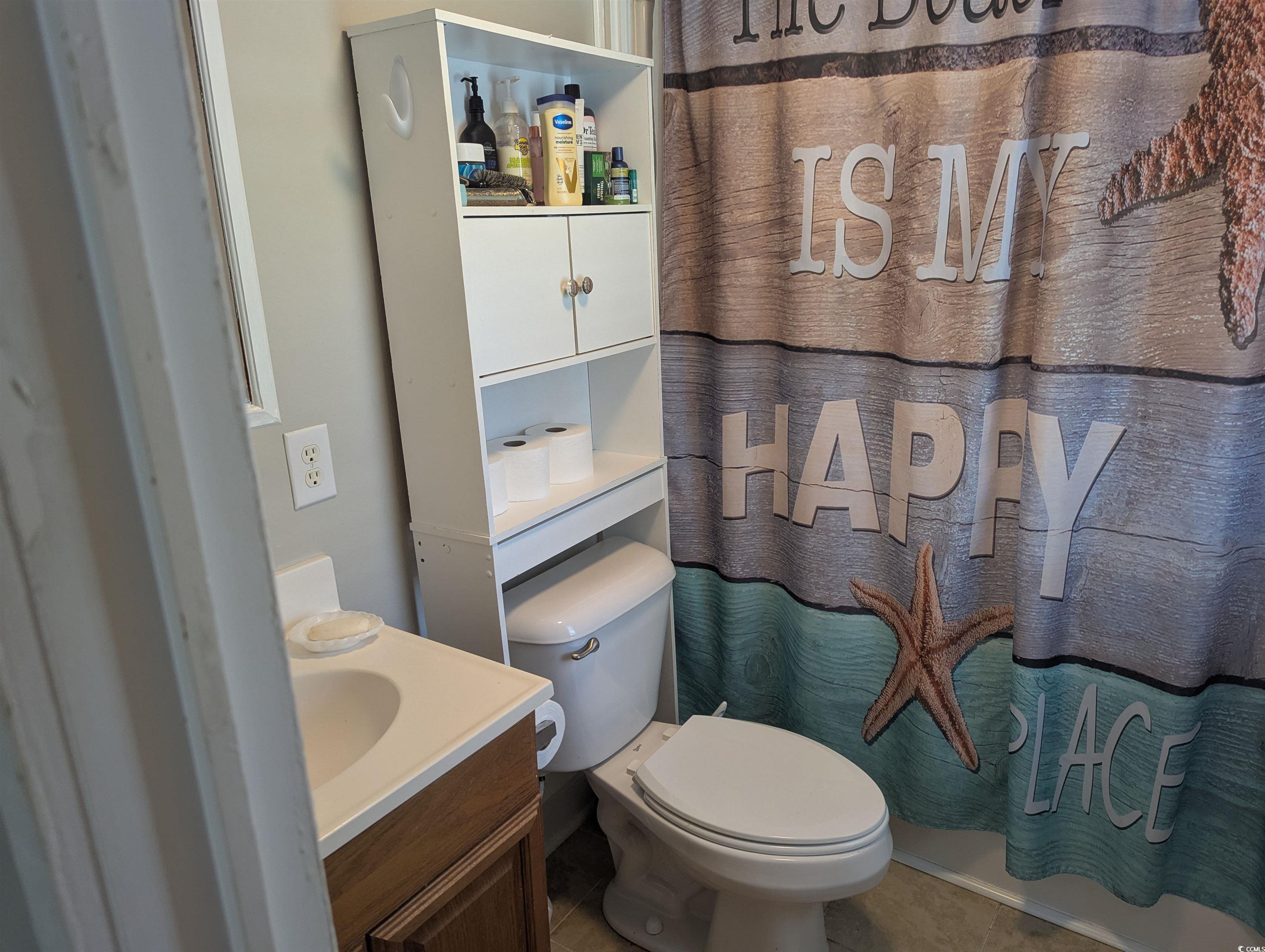 Full bathroom featuring vanity, tile patterned floors, and a shower with curtain