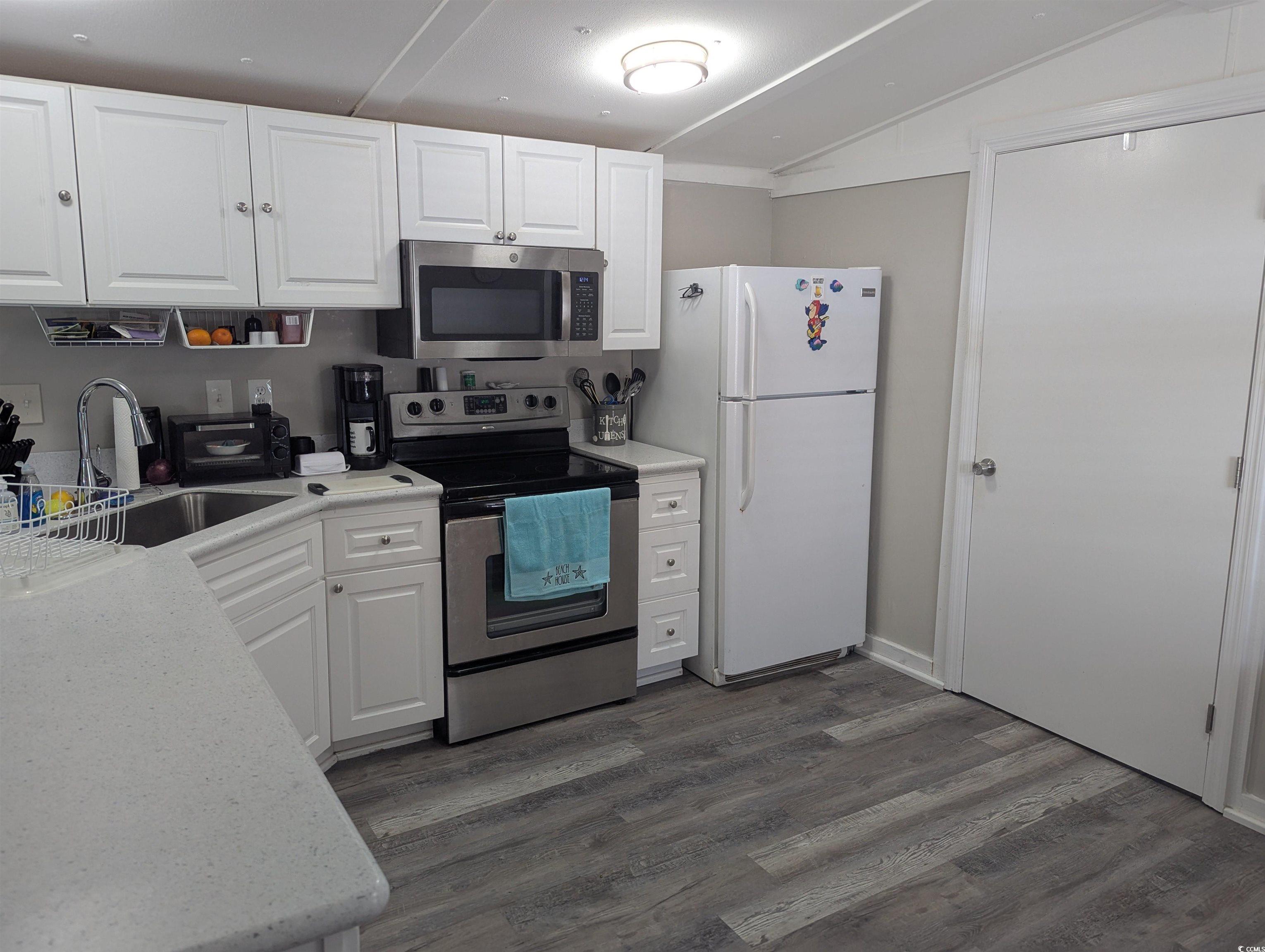 148 Offshore Drive Murrells Inlet, SC 29576 - Photo 9 of 18 Kitchen with appliances with stainless steel finishes, white cabinets, lofted ceiling, and dark wood-style flooring