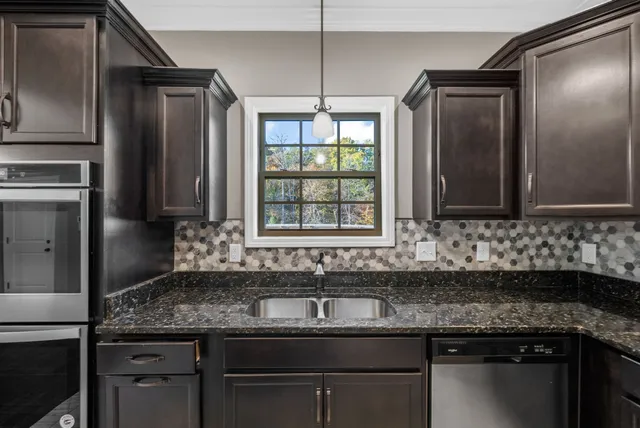a kitchen with granite countertop a sink and a refrigerator