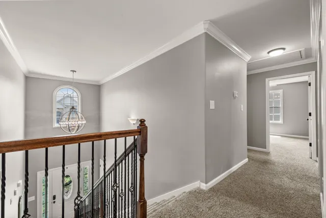 a view of a hallway to rooms and stairs