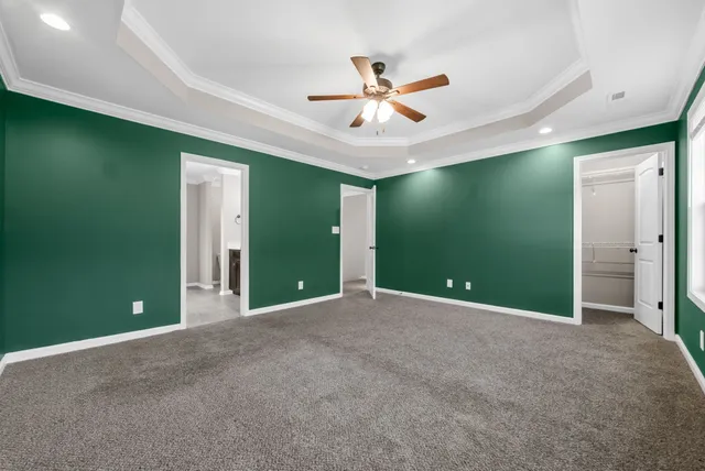 a view of a livingroom with a ceiling fan & entryway