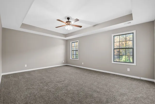 an empty room with windows and fan