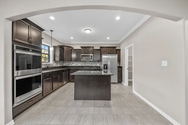 a kitchen with stainless steel appliances granite countertop a refrigerator and a sink