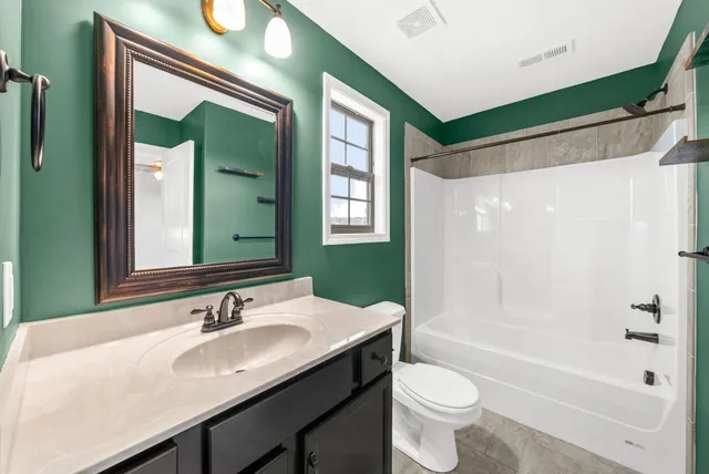 a bathroom with a granite countertop sink toilet and shower