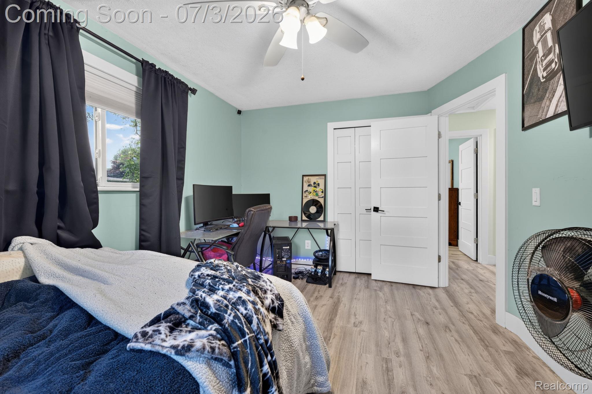 5355 North Seymour Road Flushing, MI 48433 - Photo 32 of 41 Spacious interior featuring light green walls, wood-finish flooring, a white ceiling fan, and modern white doors with black hardware