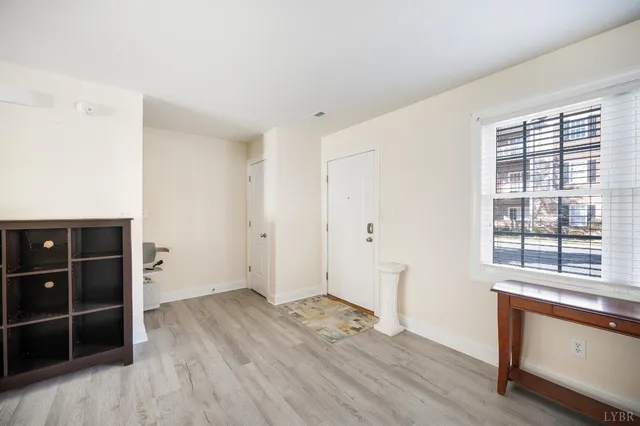 an empty room with wooden floor and window