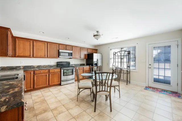 a kitchen with granite countertop a sink cabinets and stainless steel appliances