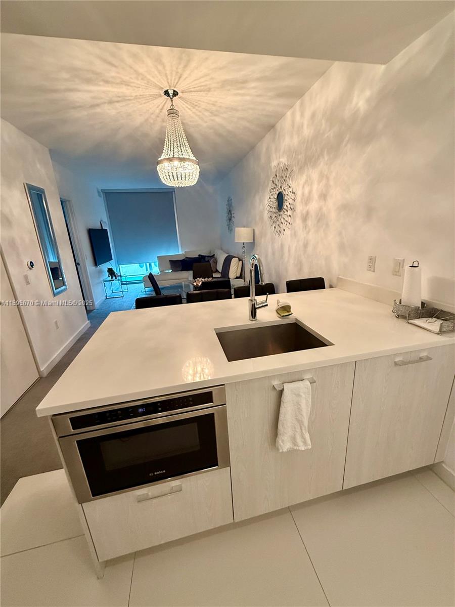 501 Northeast 31st Street, Unit 602 Miami, FL 33137 - Photo 3 of 38 a kitchen with a stove a sink and a refrigerator