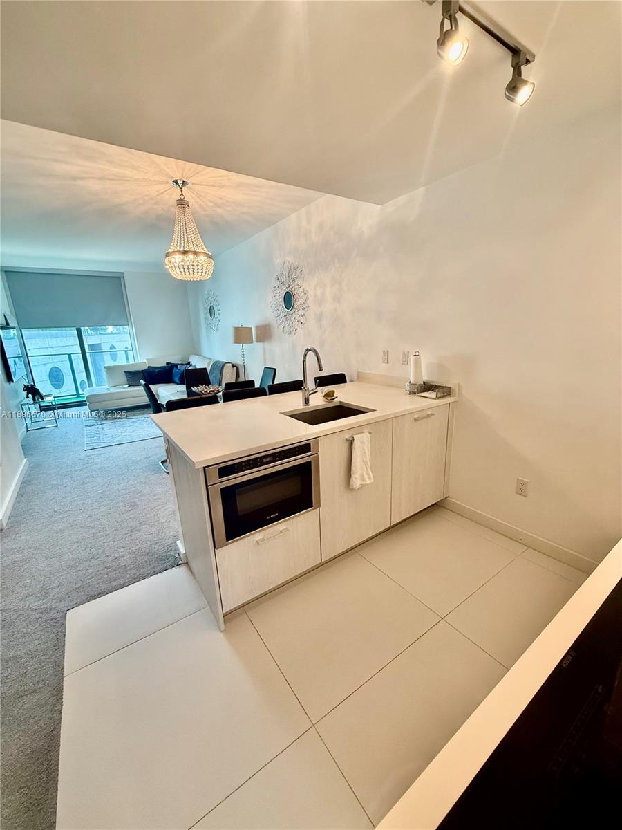 501 Northeast 31st Street, Unit 602 Miami, FL 33137 - Photo 5 of 38 a kitchen with stainless steel appliances granite countertop a sink and a stove