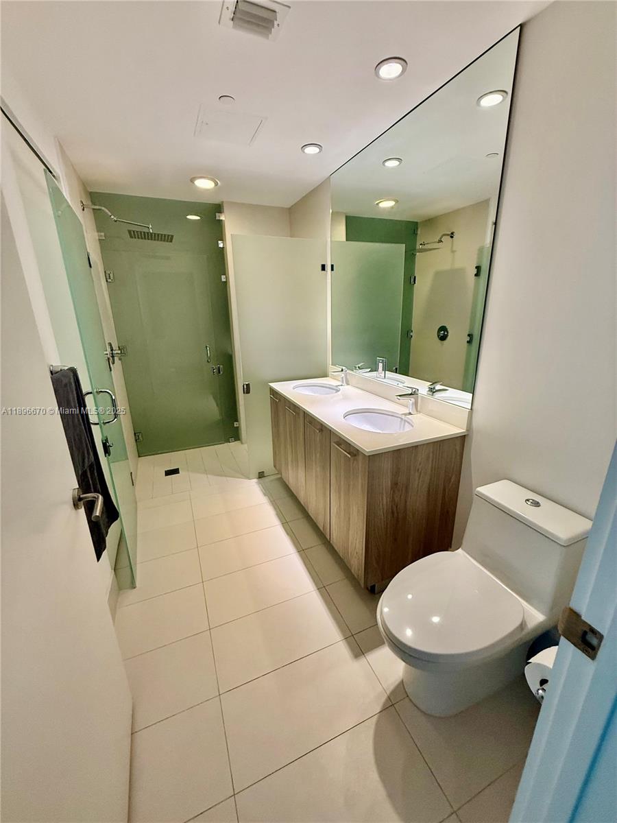 501 Northeast 31st Street, Unit 602 Miami, FL 33137 - Photo 6 of 38 a bathroom with a sink a toilet and a mirror