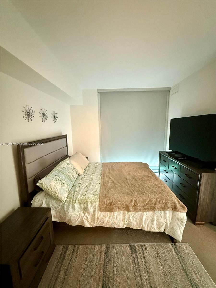 501 Northeast 31st Street, Unit 602 Miami, FL 33137 - Photo 7 of 38 a bedroom with a bed and a flat screen tv
