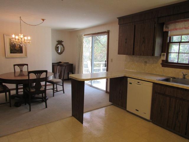 1 Keith Road Pocasset, MA 02559 - Photo 9 of 25 a kitchen with granite countertop a stove a sink a dining table and chairs