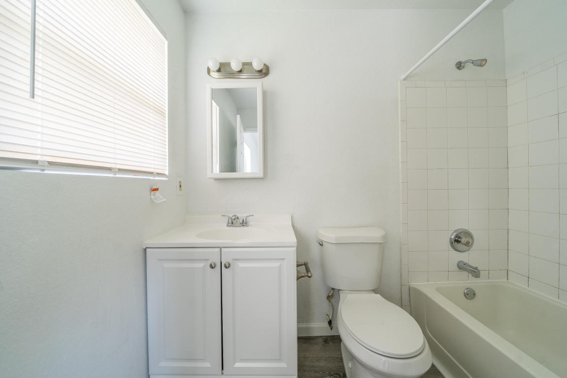 507 Northwest 3rd Street Delray Beach, FL 33444 - Photo 24 of 30 a bathroom with a toilet a sink a mirror and a bathtub