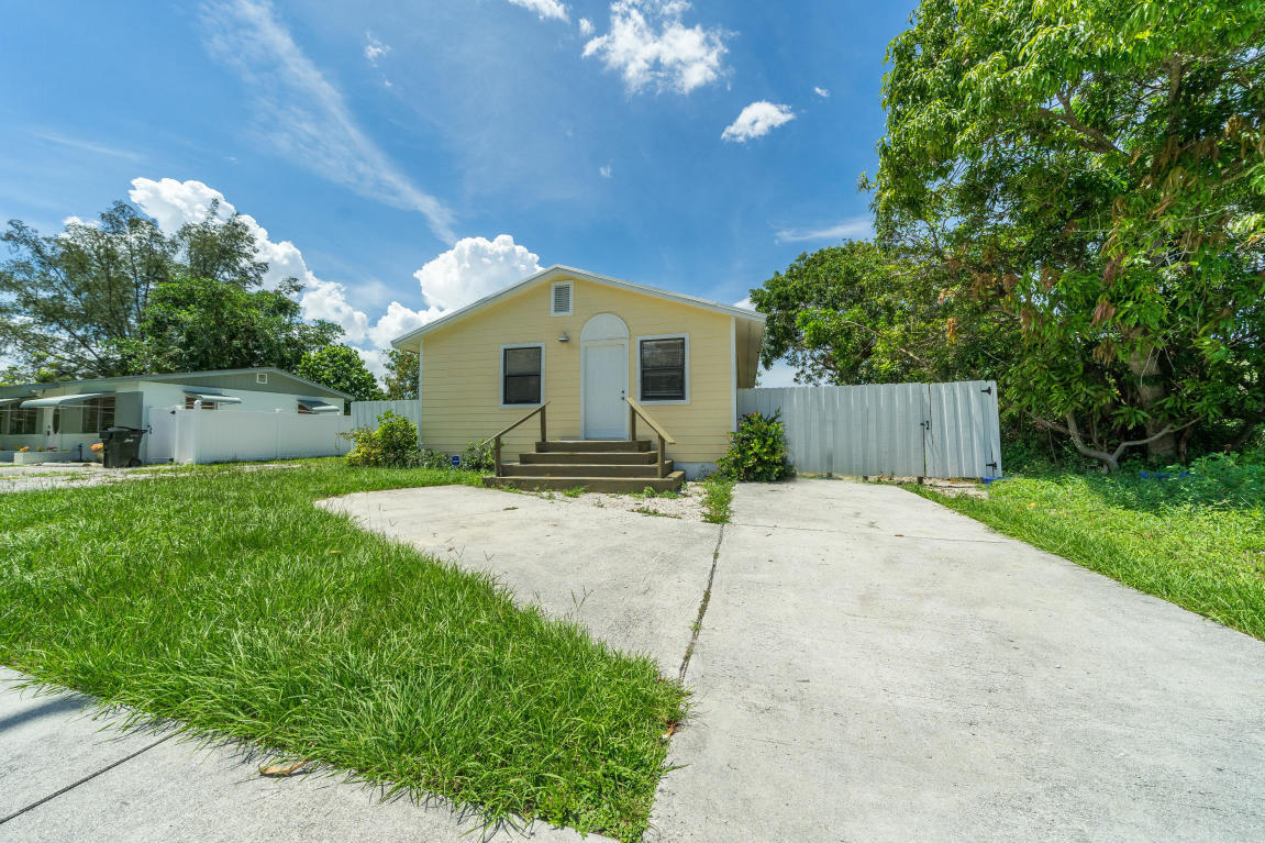 507 Northwest 3rd Street Delray Beach, FL 33444 - Photo 3 of 30 a front view of a house with a garden and trees