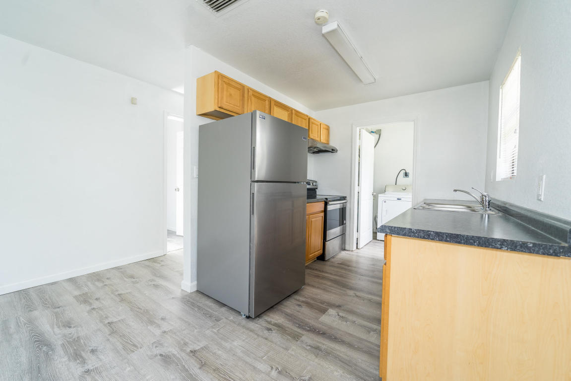 507 Northwest 3rd Street Delray Beach, FL 33444 - Photo 7 of 30 a kitchen with granite countertop a refrigerator and a sink