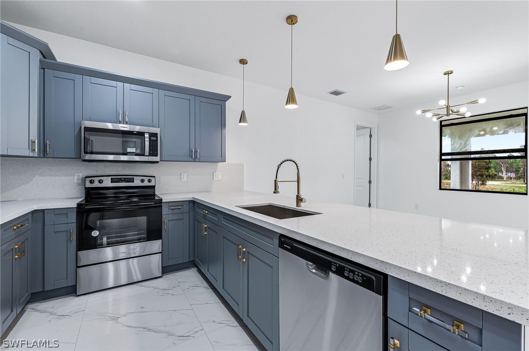 1519 Meadow Road Lehigh Acres, FL 33976 - Photo 11 of 32 a kitchen with stainless steel appliances a sink a stove a microwave and wooden cabinets