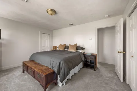a spacious bedroom with a bed and a cabinets