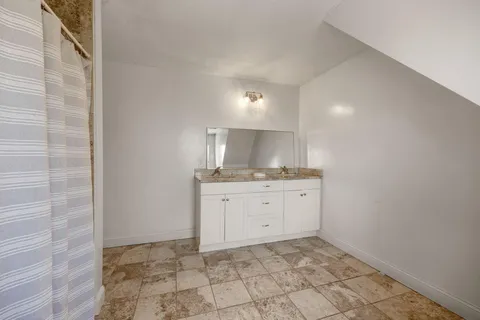 a room with a granite countertop sink and cabinets