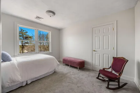 a bedroom with a bed chair and window