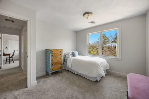 a bedroom with a bed and a painting on the wall