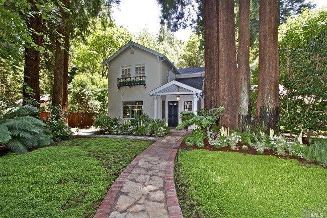 a front view of a house with a garden
