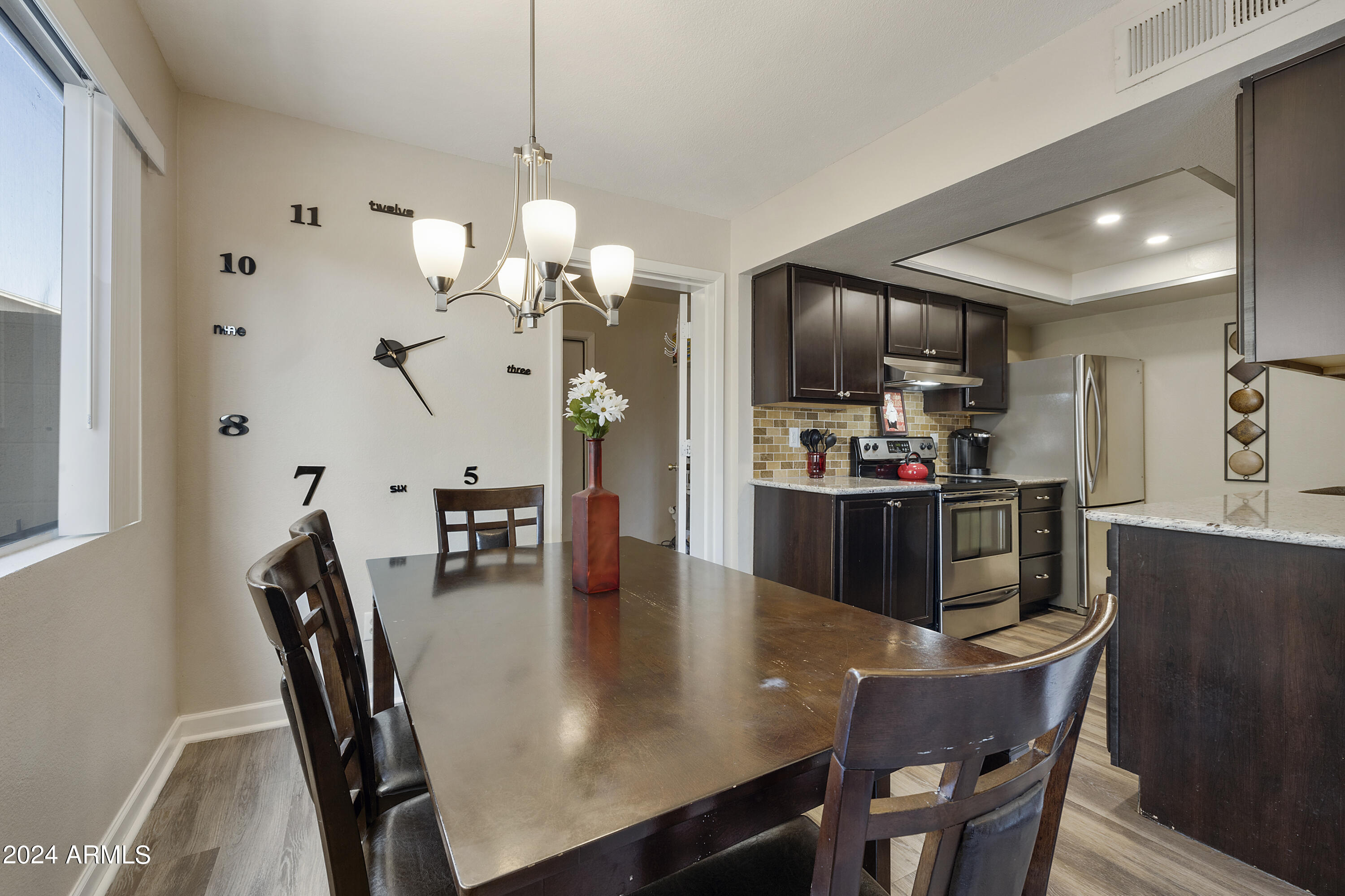 1223 North Granite Reef Road Scottsdale, AZ 85257 - Photo 12 of 35 a kitchen with kitchen island a dining table chairs stainless steel appliances and cabinets