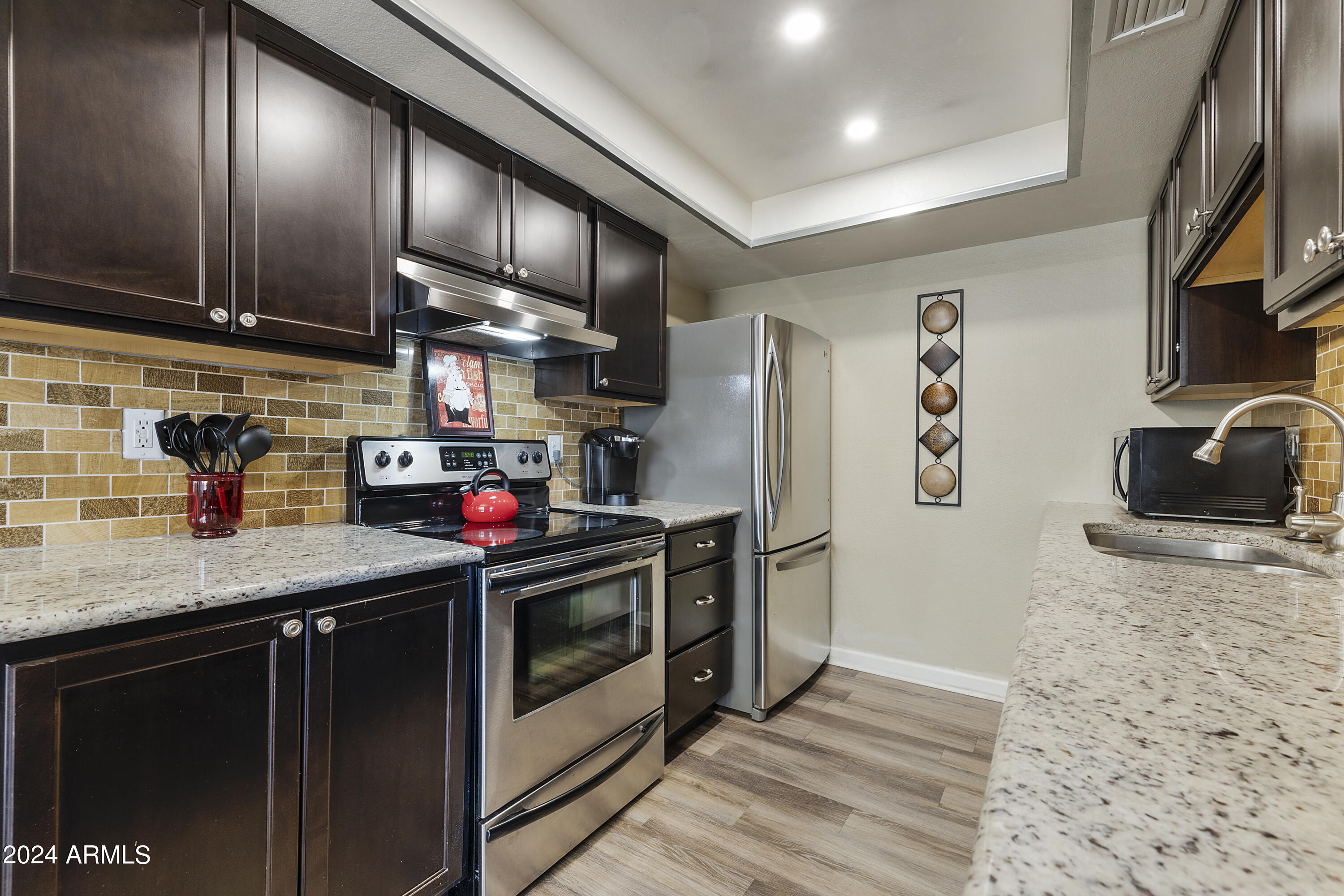 1223 North Granite Reef Road Scottsdale, AZ 85257 - Photo 15 of 35 a kitchen with stainless steel appliances granite countertop a sink stove and refrigerator