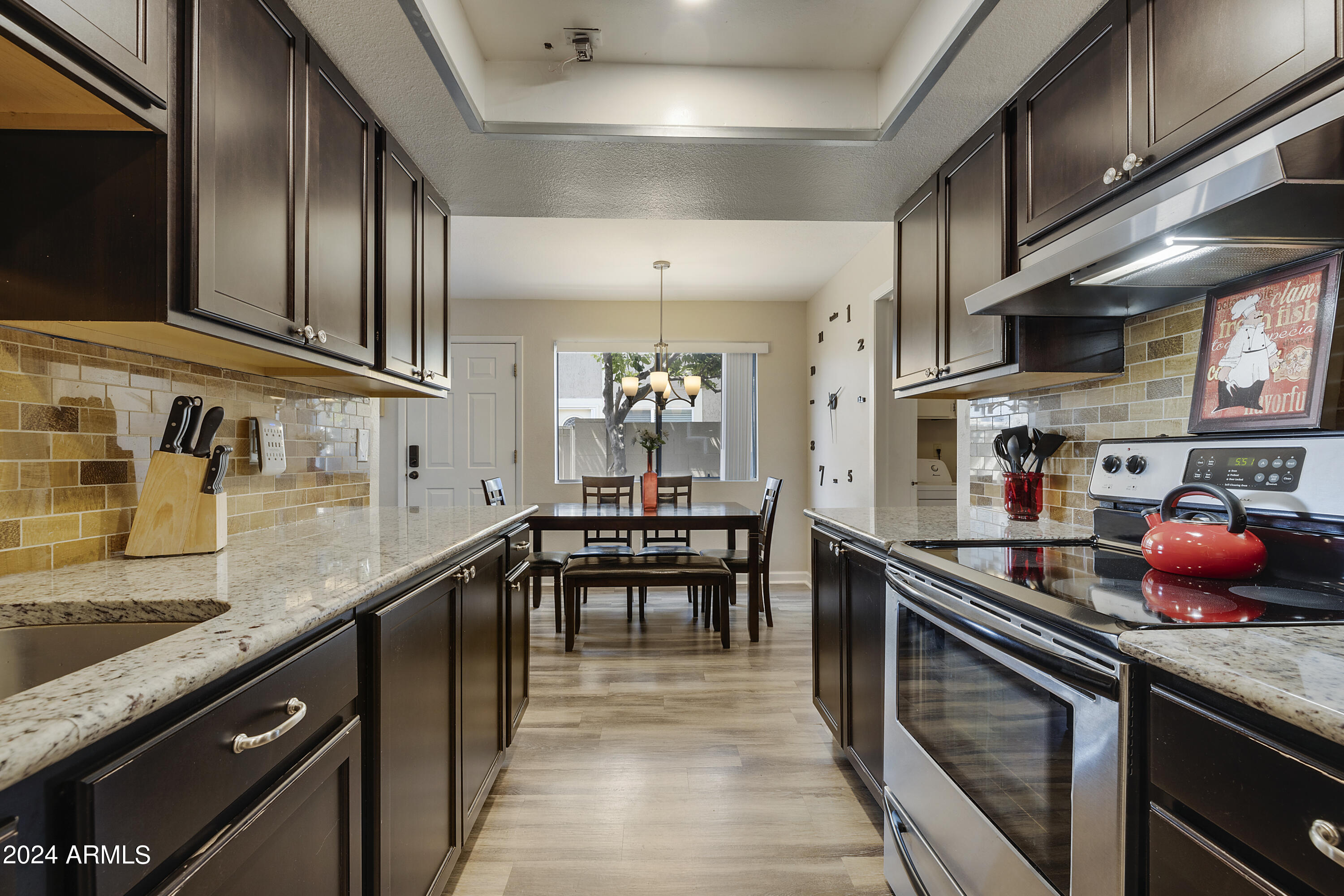 1223 North Granite Reef Road Scottsdale, AZ 85257 - Photo 3 of 35 a kitchen with stainless steel appliances granite countertop a sink and stove