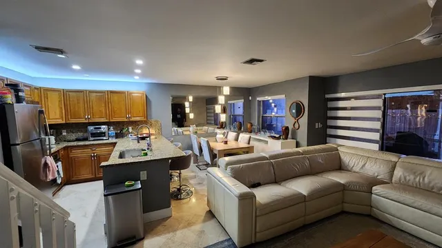 a living room with furniture kitchen view and a refrigerator