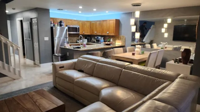 a living room with furniture and a view of kitchen