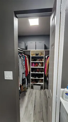 a view of walk in closet with clothes and shoes