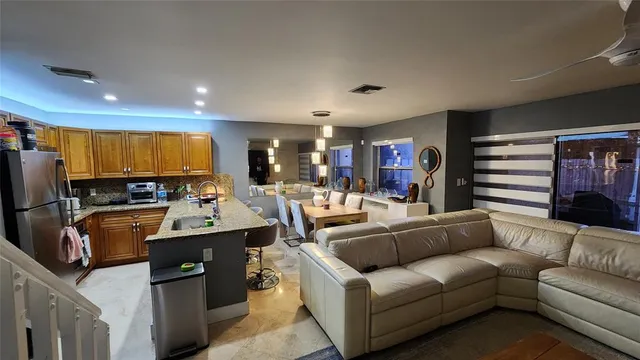 a living room with furniture kitchen view and a refrigerator