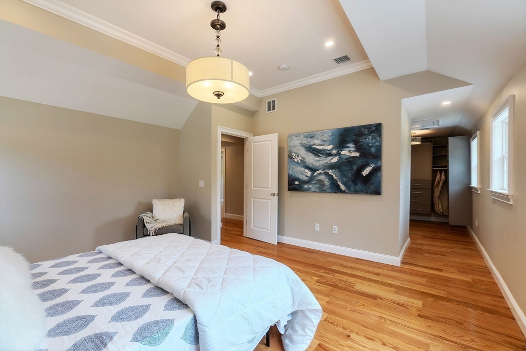 269 Dale Street, Unit 1 Waltham, MA 02451 - Photo 19 of 42 a bedroom with a bed and a chandelier