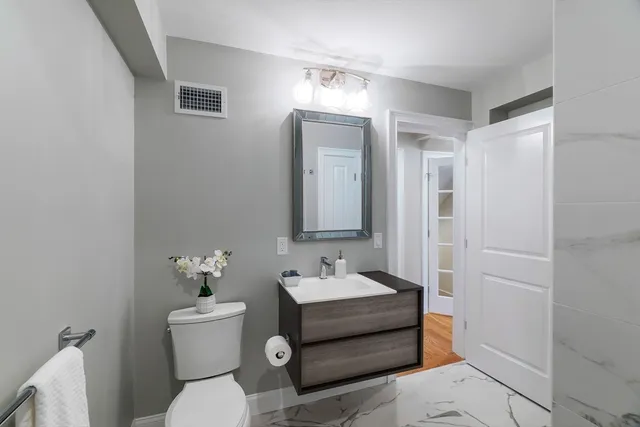 a bathroom with a sink toilet and mirror