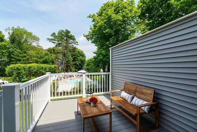 a balcony with wooden floor and outdoor seating