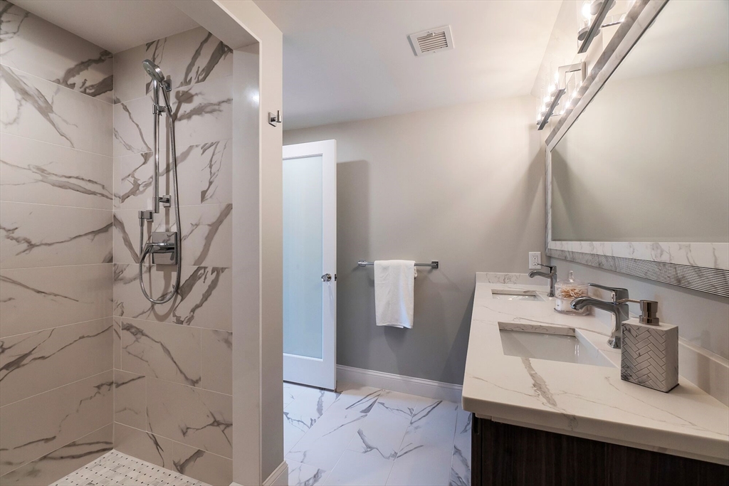 269 Dale Street, Unit 1 Waltham, MA 02451 - Photo 36 of 42 a bathroom with a sink and mirror with bathtub