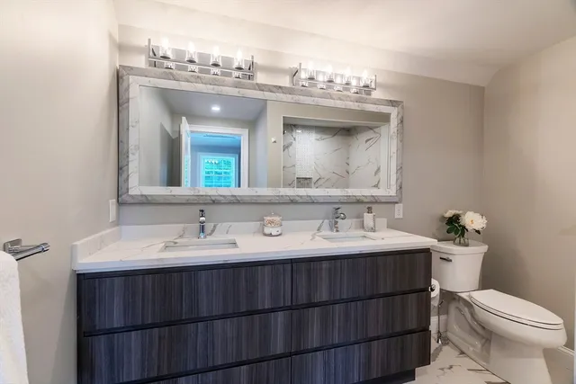 a bathroom with a toilet sink and mirror