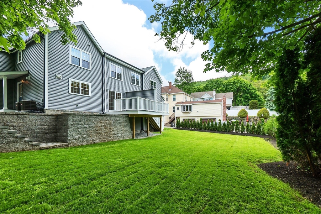 269 Dale Street, Unit 1 Waltham, MA 02451 - Photo 41 of 42 a front view of a house with a yard and trees