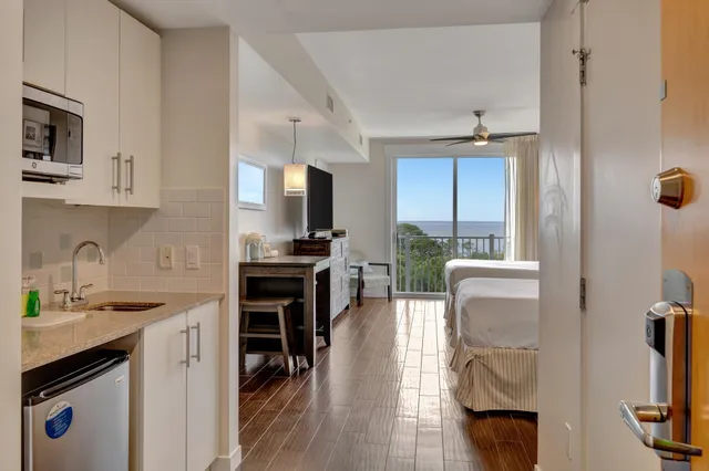 a kitchen with stainless steel appliances granite countertop a stove refrigerator and a sink with wooden floor