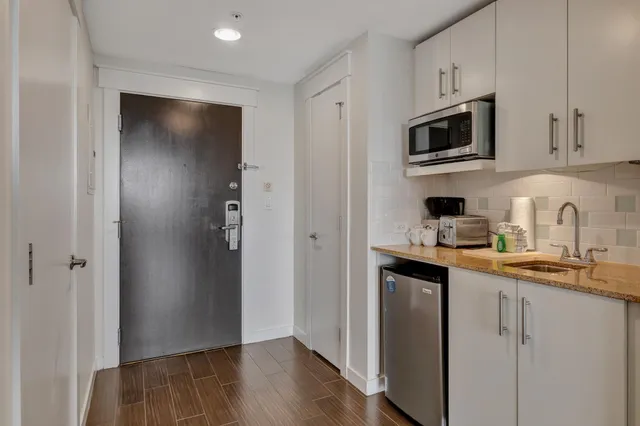a kitchen with stainless steel appliances granite countertop a refrigerator and a sink