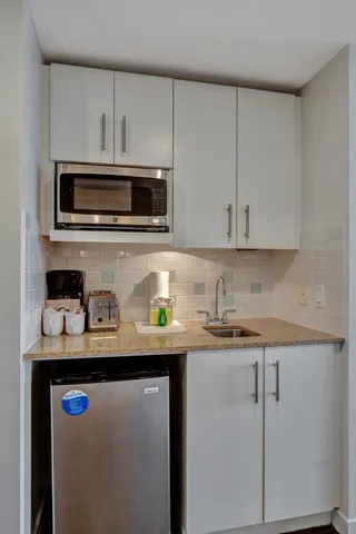 a kitchen with stainless steel appliances granite countertop a sink stove and microwave