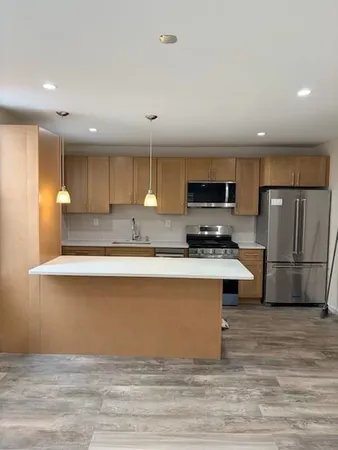 a kitchen with stainless steel appliances granite countertop a stove a sink and a refrigerator