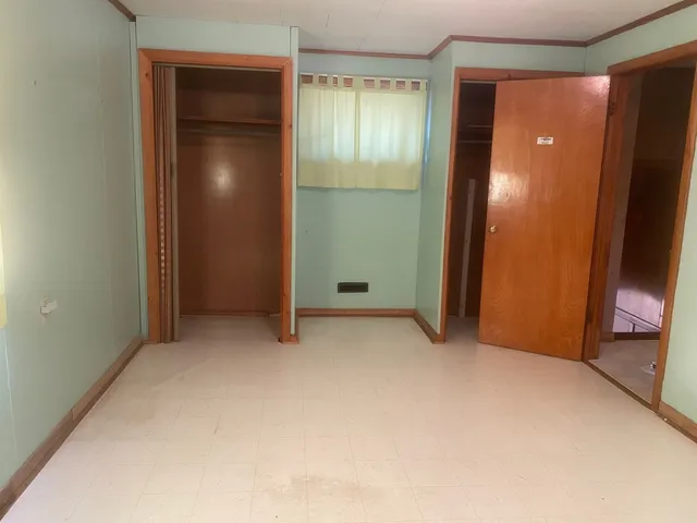 an empty room with closet and mirror