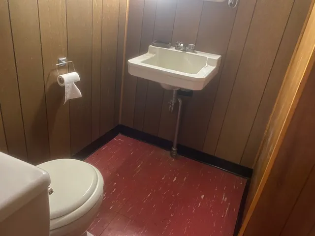 a bathroom with a sink a toilet and mirror