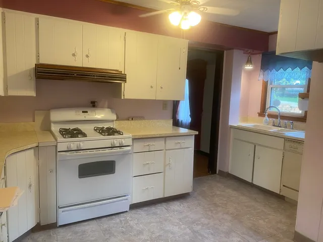 a kitchen with cabinets appliances and a sink
