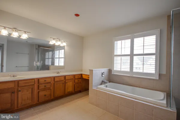 a bathroom with a tub sink and mirror