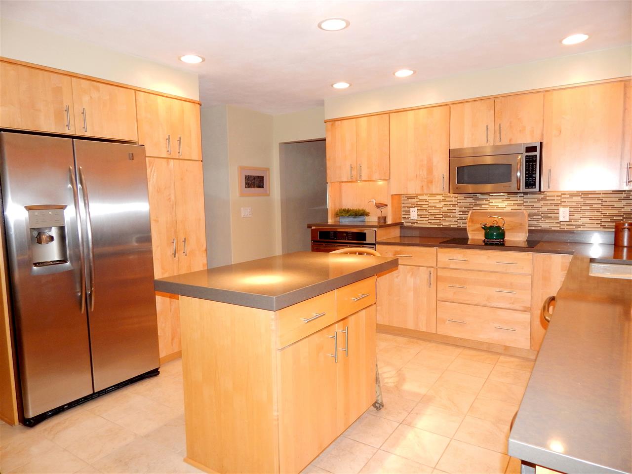 210 Lovesee Road Roscoe, IL 61073 - Photo 10 of 25 a kitchen with stainless steel appliances kitchen island granite countertop a refrigerator a stove and a sink with wooden floor